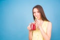 Beautiful young woman drinks strawberry smoothie on blue background. Healthy organic drinks concept. People on a diet. Royalty Free Stock Photo