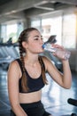 Beautiful young woman drinks water in gym. Sports nutrition concept Royalty Free Stock Photo