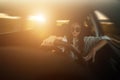 Beautiful young woman driving speeding in a car in sunset