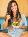 Beautiful young woman eating a bowl of healthy organic salad Royalty Free Stock Photo