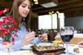 Beautiful young woman eating can of snails in the restaurant.