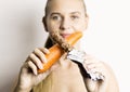 Beautiful young woman eating an carrot. carrot vs chocolate. healthy food - strong teeth concept Royalty Free Stock Photo