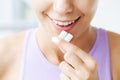 Beautiful young woman eating chewing gum, smiling Royalty Free Stock Photo