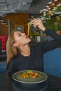 Beautiful young woman eating chinese food called Wok with chopsticks. Wok with meat and fried asparagus in a plate Royalty Free Stock Photo