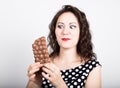 Beautiful young woman eating a chocolate bar, wears a dress with polka dots Royalty Free Stock Photo