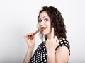 Beautiful young woman eating a chocolate bar, wears a dress with polka dots. expresses different emotions Royalty Free Stock Photo