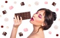 Beautiful young woman is eating chocolate on white background, i Royalty Free Stock Photo