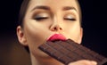 Beautiful young woman eating dark chocolate. Beauty girl enjoying chocolate Royalty Free Stock Photo