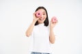 Beautiful young woman eating delicious glazed dougnuts, holding two pink donuts and smiling, white background Royalty Free Stock Photo