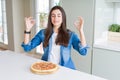 Beautiful young woman eating homemade tasty pizza at the kitchen relax and smiling with eyes closed doing meditation gesture with