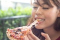 Beautiful young woman eating a piece of Italian pizza in cafe, Her feeling enjoyment Royalty Free Stock Photo