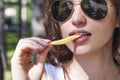 Beautiful, young woman eating pizza and fries in the street. The concept of fast food, food delivery and lunch in nature Royalty Free Stock Photo