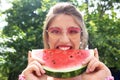 Beautiful young woman eating slice of tasty watermelon outdoors Royalty Free Stock Photo