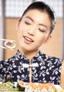 Beautiful young woman eating sushi. Royalty Free Stock Photo