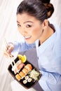 Beautiful young woman eating sushi. Royalty Free Stock Photo