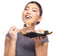 Beautiful young woman eating sushi. Royalty Free Stock Photo