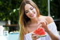 Beautiful young woman eating watermelon in the home garden. Royalty Free Stock Photo