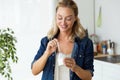 Beautiful young woman eating yogurt at home. Royalty Free Stock Photo