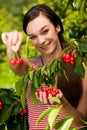 Beautiful young woman eats cherry on plantation Royalty Free Stock Photo