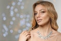 Beautiful young woman with elegant jewelry against defocused lights Royalty Free Stock Photo