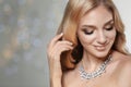 Beautiful young woman with elegant jewelry against defocused lights Royalty Free Stock Photo