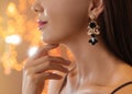 Beautiful young woman with elegant jewelry against defocused lights, closeup. Royalty Free Stock Photo