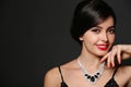 Beautiful young woman with elegant jewelry on dark background Royalty Free Stock Photo