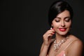 Beautiful young woman with elegant jewelry on dark background Royalty Free Stock Photo