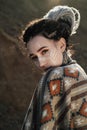 Beautiful young woman with elf ears, dreadlocks and an ethnic poncho, with painted face. Posing against a sandy career Royalty Free Stock Photo