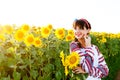 Beautiful young woman in embrodery holding three sunflowers Royalty Free Stock Photo