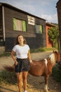 Beautiful Young Woman in Countryside at a Horse Farm and Posing in Front of a Pony Horse Royalty Free Stock Photo