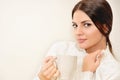 Beautiful young woman enjoying a cup of coffee while relaxing at home