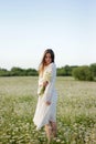 Beautiful young woman enjoying a field of daisies, beautiful girl relaxing outdoors, having fun Royalty Free Stock Photo