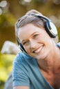 Beautiful young woman enjoying music in park