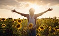 Beautiful young woman enjoying nature on the field of sunflowers at sunset Royalty Free Stock Photo