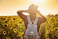 Beautiful young woman enjoying nature on the field of sunflowers at sunset Royalty Free Stock Photo