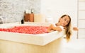 Beautiful woman enjoying romantic flowers bath