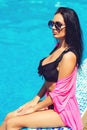 Beautiful young woman enjoying summer vacation. Girl wears trendy sunglasses and swimsuit Royalty Free Stock Photo