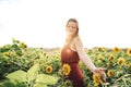 Beautiful young woman enjoying beautiful sunflowers blooming in farm on sunny day Royalty Free Stock Photo