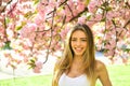 Beautiful young woman enjoying sunny day in park during cherry blossom season on a nice spring day. Royalty Free Stock Photo