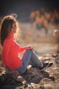 Beautiful young smiling woman enjoys the beauty Valley along the hiking trail posing on the rock on sunny day in Altai