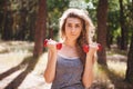 Beautiful young woman exercising with red dumbbells, fitness sport in summer