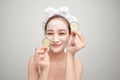 Beautiful young woman with facial mask on her face holding slices of fresh cucumber Royalty Free Stock Photo