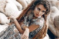 Beautiful young woman with feathers in hair outdoors close up portrait