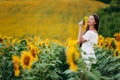 Beautiful young Woman in the field of sunflowers. girl with long brunette hair inhales aroma of wild flower. Summer time Royalty Free Stock Photo