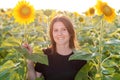 Beautiful young woman in a field of sunflowers. young woman stands among the sunflowers and smiles Royalty Free Stock Photo