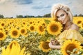 Beautiful young woman in a field of sunflowers in a yellow dress Royalty Free Stock Photo