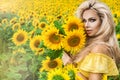 Beautiful young woman in a field of sunflowers in a yellow dress Royalty Free Stock Photo