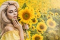 Beautiful young woman in a field of sunflowers in a yellow dress