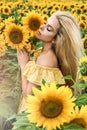 Beautiful young woman in a field of sunflowers in a yellow dress Royalty Free Stock Photo